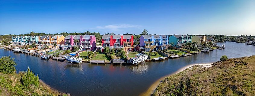 Colorful houses along the bay in Navarre, Florida: A scenic waterfront community with vibrant facades, small boats docked in front of the homes, and a panoramic view of the neighborhood.