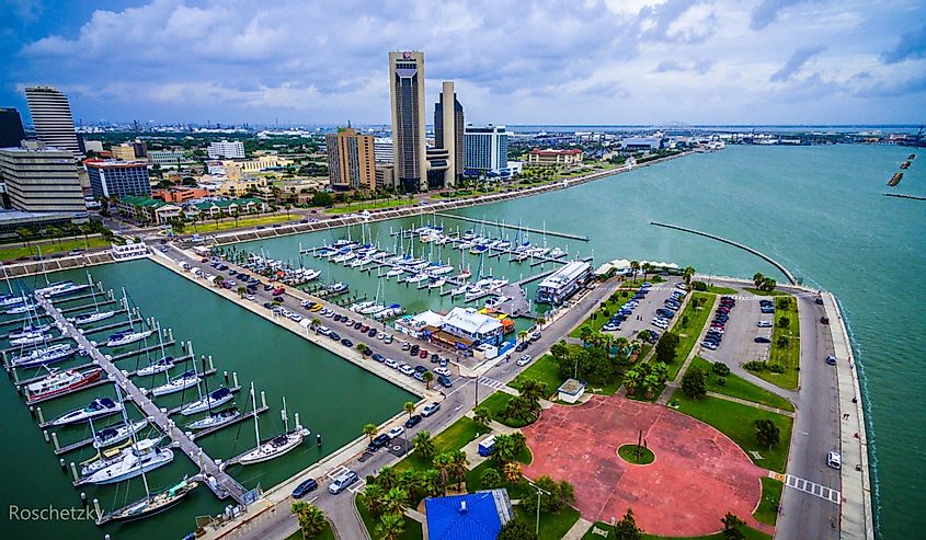 Corpus Christi Texas Skyline view of City harbor bridge in background with many rows of piers filled with boats and sailboats and yachts across the summer vacation landmark getaway