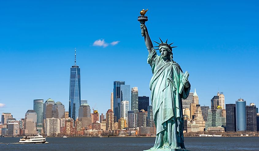Статуя Свободы над рекой городского пейзажа Нью-Йорка