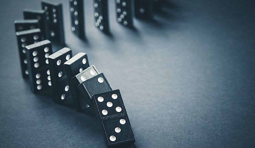 Black dominoes chain on a dark table background
