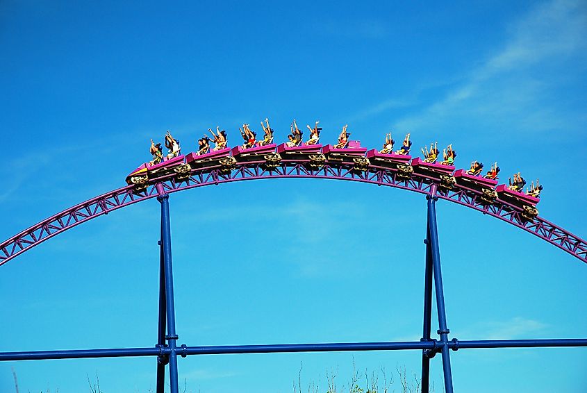 Riders raise their arms as they crest a hill on a roller coaster in Agawam, Massachusetts