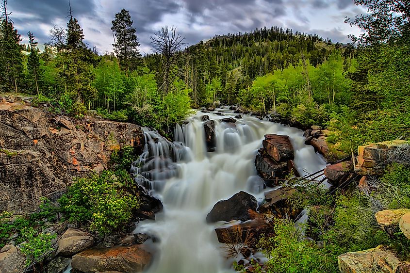 Lander, Wyoming: Sinks Canyon landscape with trees, waterfall, and river.