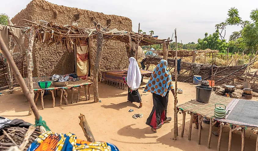 People walking in the sand in a small village in the Sahel.