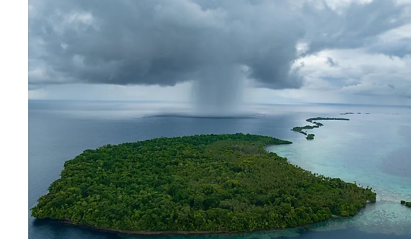 Storm clouds dump rain near a remote tropical island in the Solomon Islands