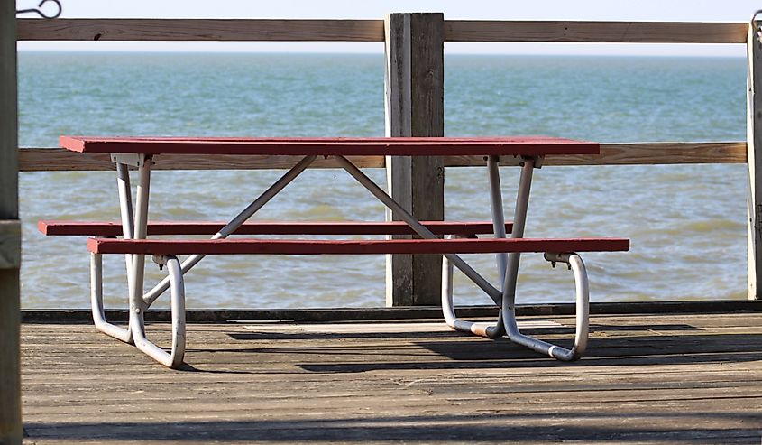 Red picnic table on a deck overlooking Sheffield Lake, Lake Erie. 