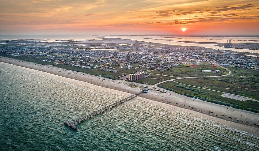 Aerial view of Port Aransas at sunset with boat speeding in the water