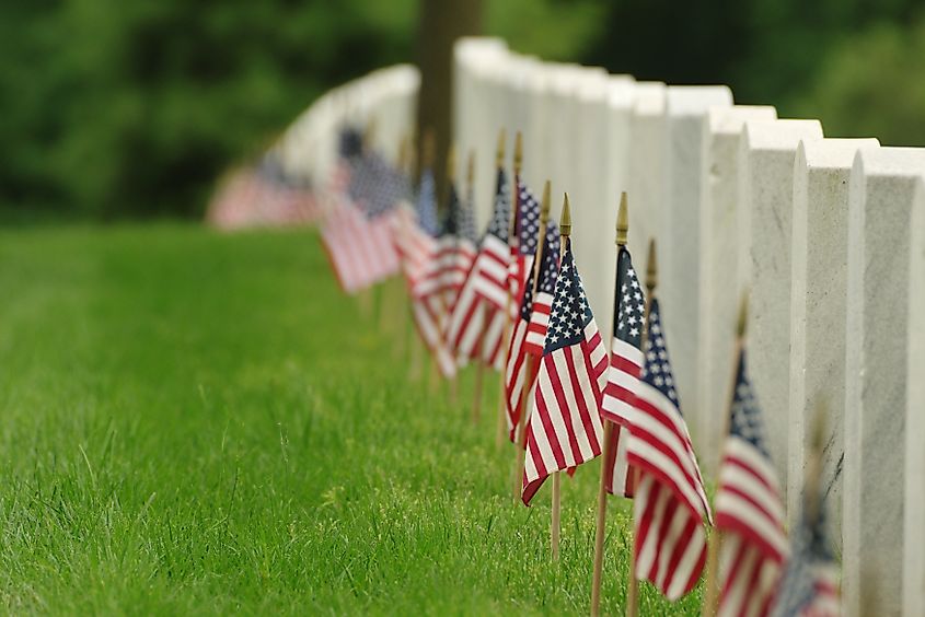 Grave markers with American flags at Arlington National Cemetery.