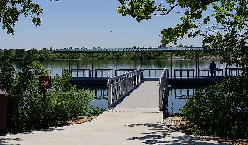 Wide shot of the floating dock with the silhouette of an unrecognizable man at the Veteran Lake, Sulphur, Oklahoma