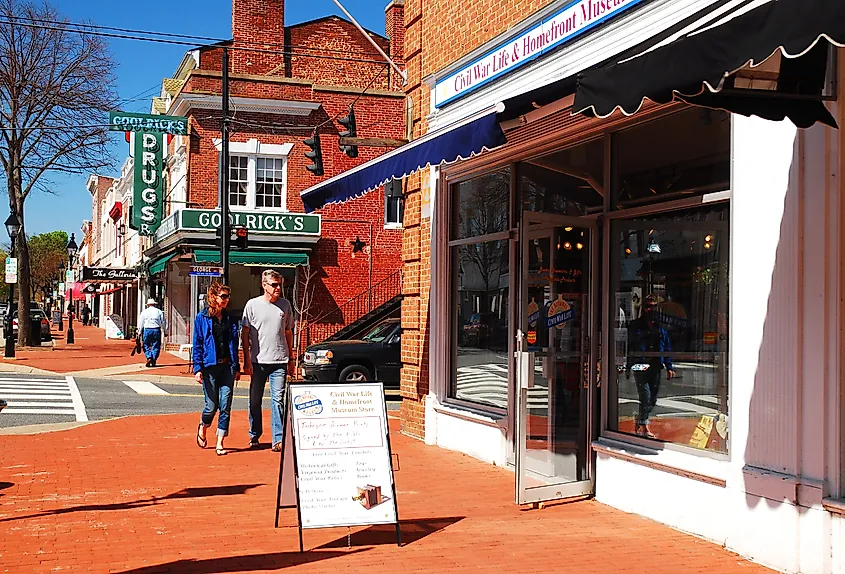 A couple walks through Fredericksburg, Virginia, past a Civil War Museum.