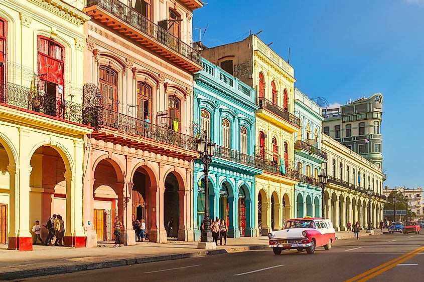 Street scene with classic old cars and traditional colorful buildings in downtown Havana