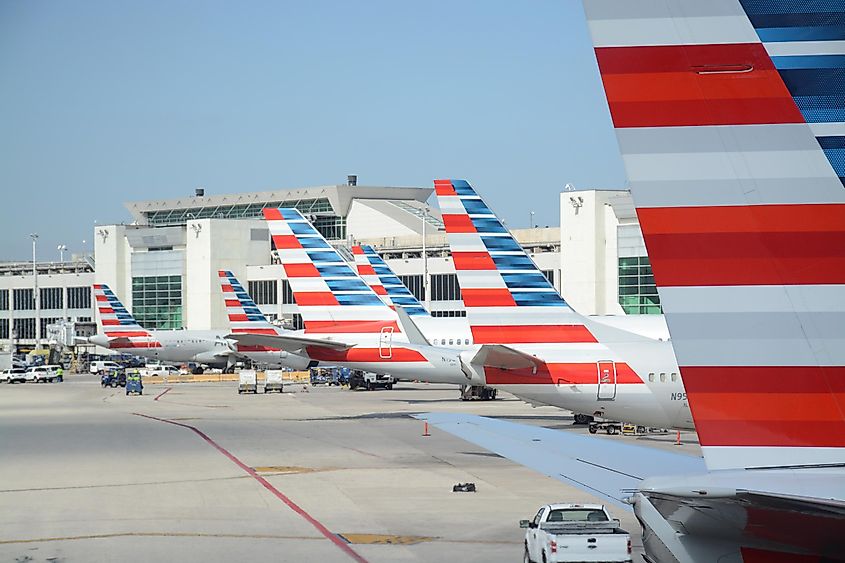 Tail wings of American Airlines lined up in a row at their gates