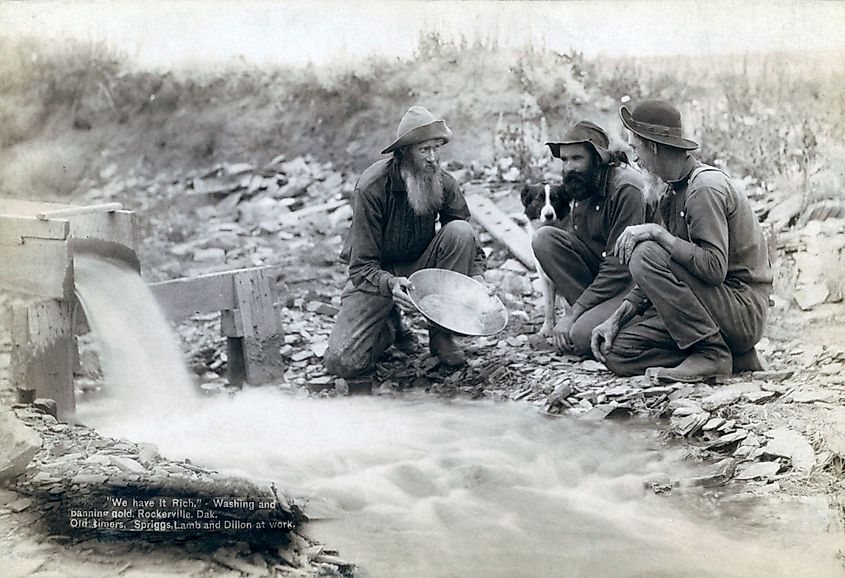 Three men panning for gold in a stream in the Black Hills of South Dakota