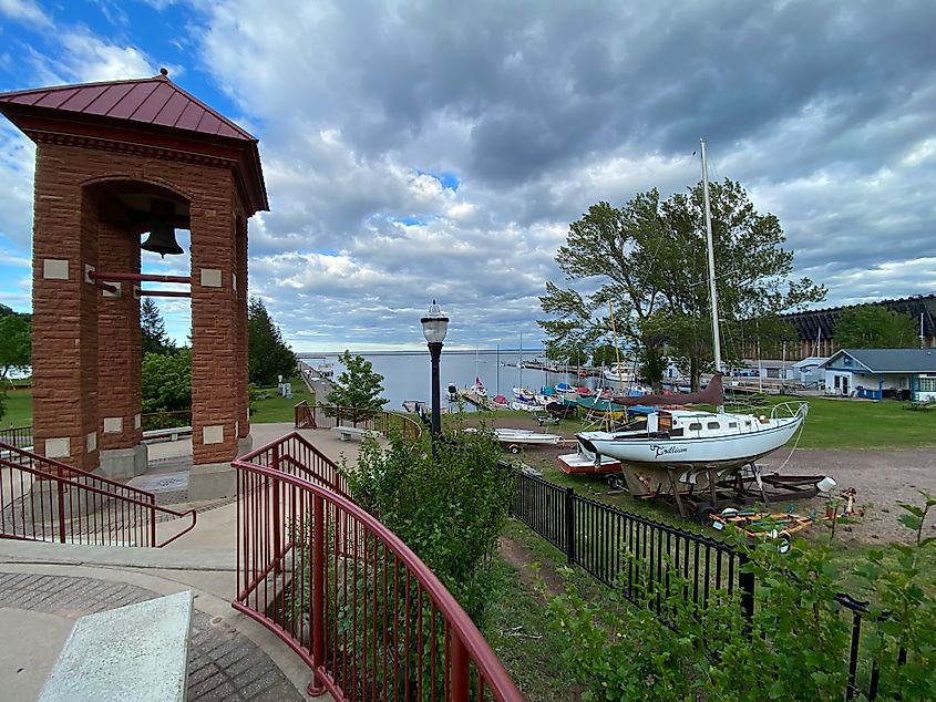 A fire bell stands before a modest lake marina.