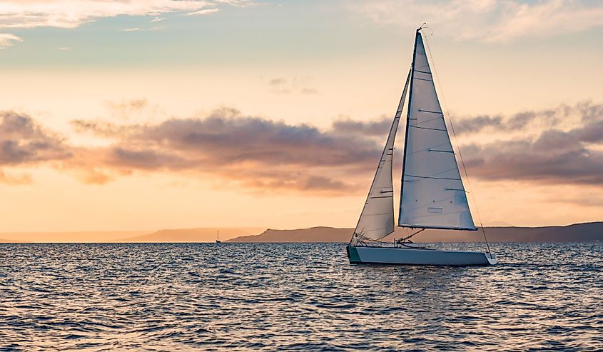 Sailboats on the background of the sunset over the sea