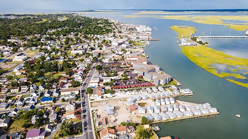 Chincoteague Island, marinas, houses and motels with parking lots. bridge and road along the bay. Drone view.