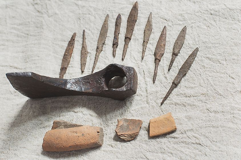 Ancient iron axe head, collection of arrowheads and pottery shards 