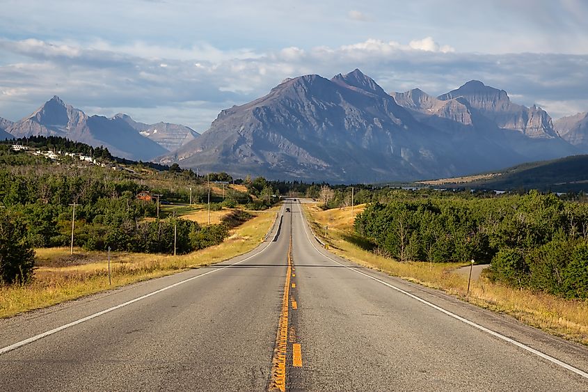 Beautiful View of Scenic Highway with American Rocky Mountain Landscape in the background during a Cloudy Summer Morning. Taken in St Mary, Montana, United States.