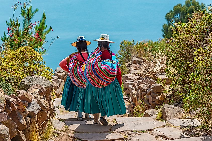 Peruvian indigenous Quechua women in traditional clothes on Taquile Island, Titicaca Lake, Peru. Credit: SL-Photography/Shutterstock.com