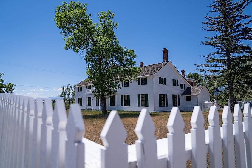  White picket fence gate leading to historic buildings at Grant-Kohrs National Historic Site Ranch in Deer Lodge, Montana.