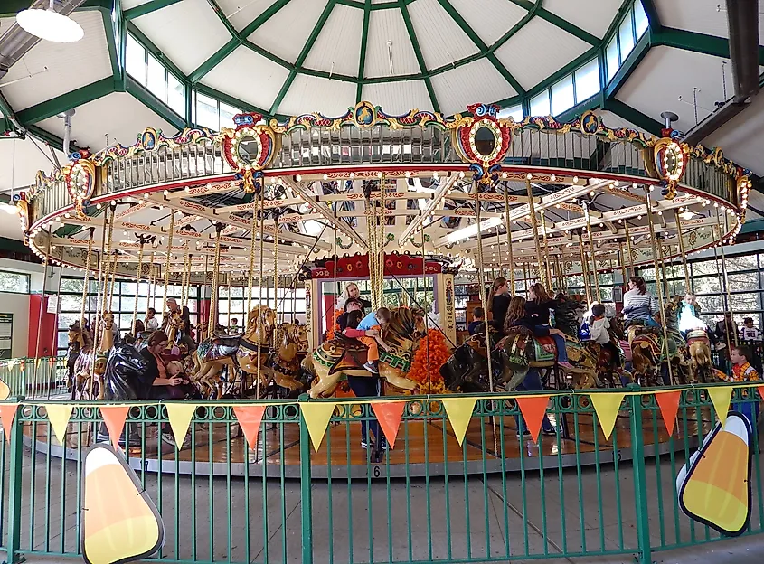 Editorial Photo Credit: MollieGPhoto via Shutterstock. Powell, Ohio, USA - October 13, 2019: Children and families riding the historic Mangel-Illions Grand Carousel at the Columbus Zoo
