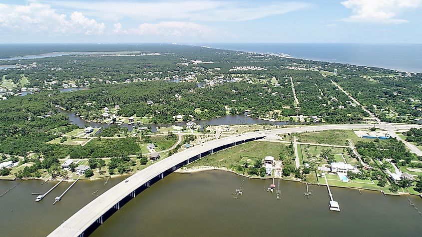 A curved highway on St Louis Bay enters land with piers on both sides.