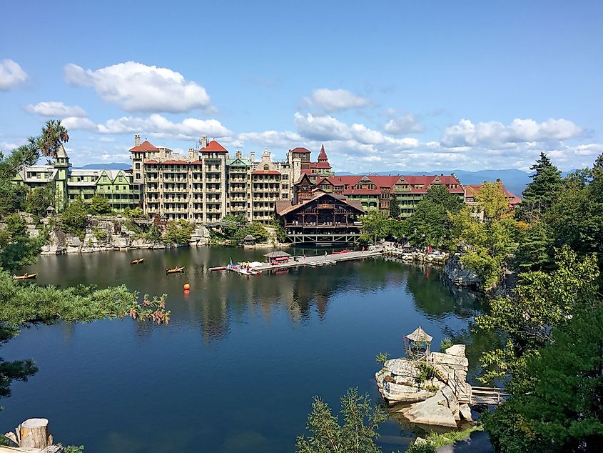 Mohonk Mountain House across a lake with a dock and a small rock island in New Paltz, New York.