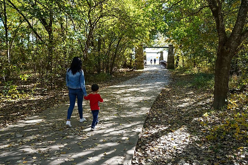 A woman walking with her son at the Oak Point Park in Plano, Texas