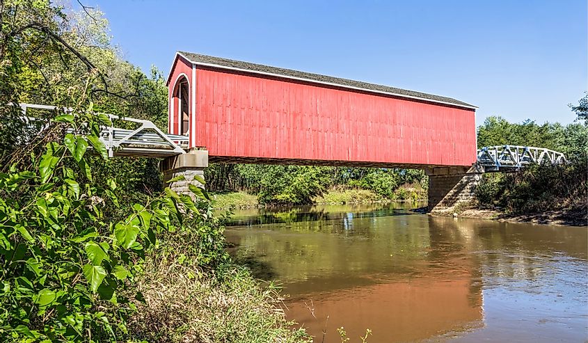 The red Wolf Covered Bridge, with pony truss approaches, crosses the Spoon River in rural Knox County, Illinois.