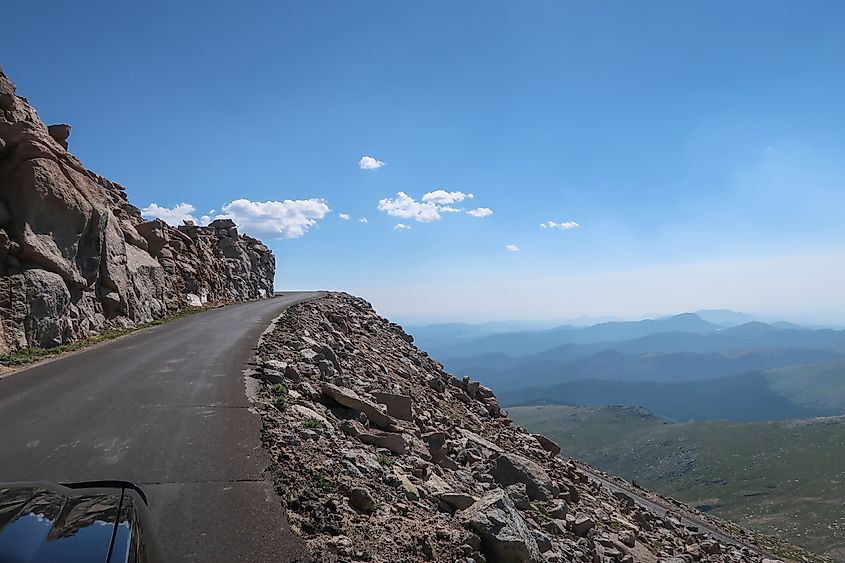  Point of view high elevation landscape of road leading up with mountains below on Mount Blue Sky Evans Scenic Byway in Colorado.