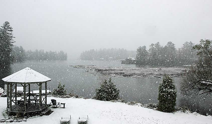 Light snow falling on Lake Placid, lawn chairs and gazebo, State of New York