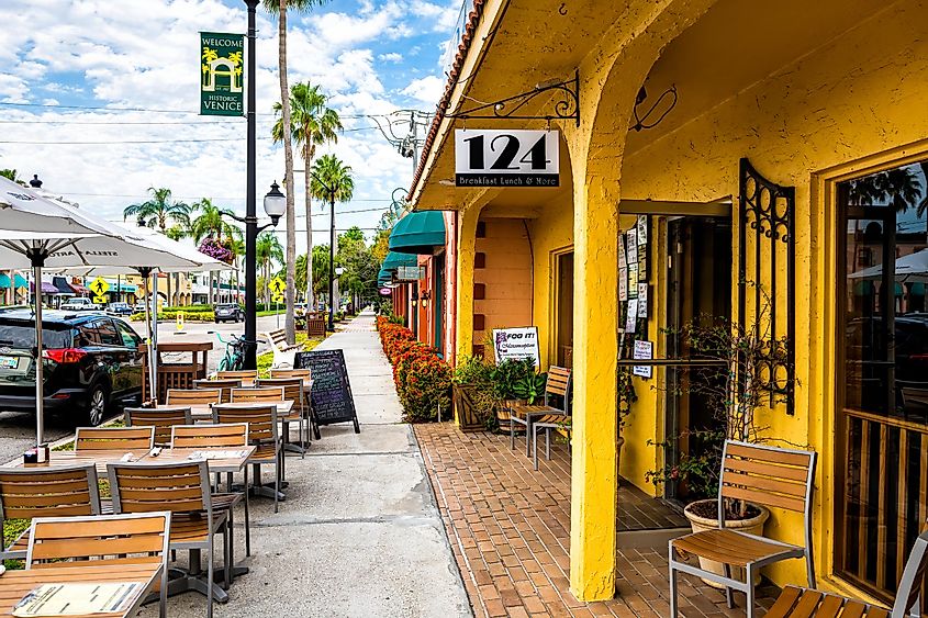 Venice, USA - April 29, 2018: Welcome to historic old town of Italian city district in Florida with 124 sidewalk restaurant with outdoor sitting area with empty chairs and tables