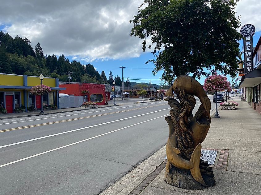A shark/seal wooden sculpture on a colorful small-town main street.