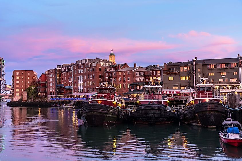 Skyline of Portsmouth, New Hampshire at dusk, with tugboats on the Piscataqua River.