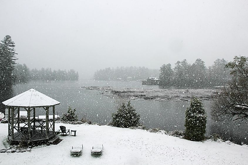 Light snow falling on Lake Placid, lawn chairs and gazebo, State of New York