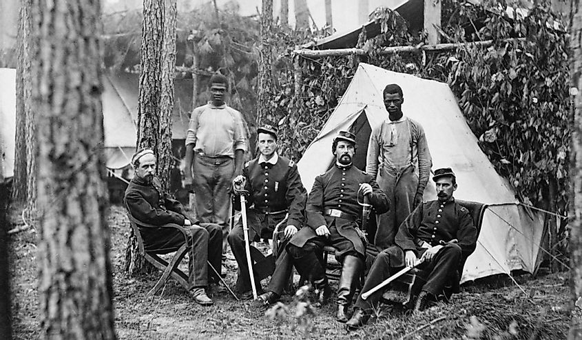 Four union officers in front of tent, with two Africans-American during the Petersburg Campaign.