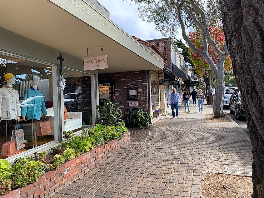 A brick sidewalk leads past charming boutique clothing shops.