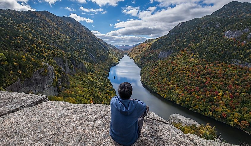 Man sitting on Indian Head Cliff at Adirondack Park, New York, USA.