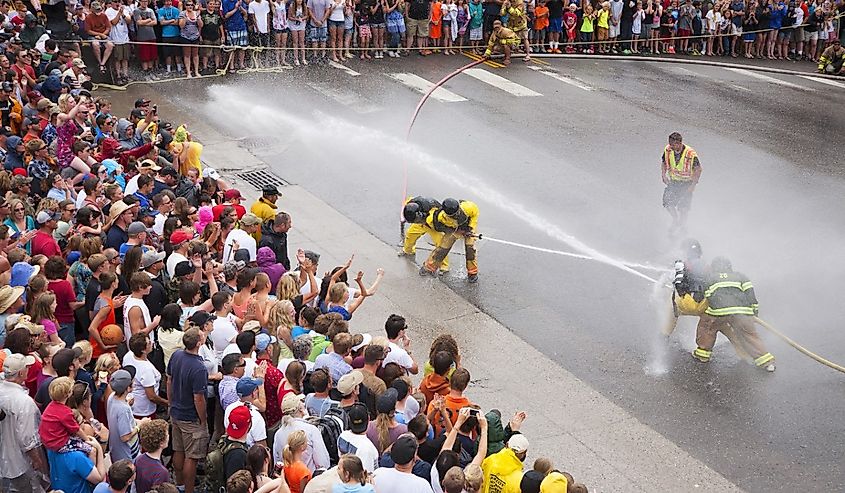 Men dressed in yellow firemen slickers and firehoses have annual Waterfight on July 4, Main Street, Ouray, CO, sponsored by Ouray Fire Department