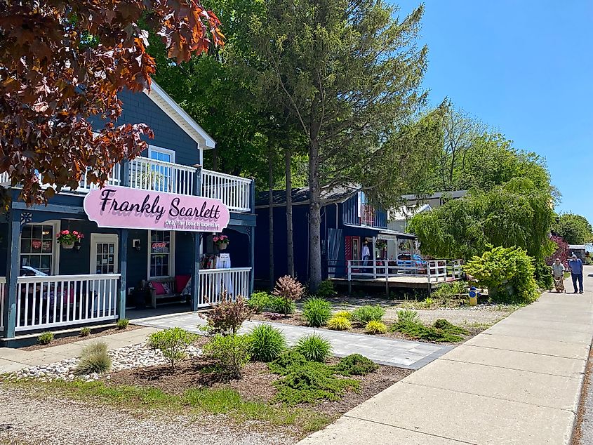 An elderly couple walks past small-town home boutique shops
