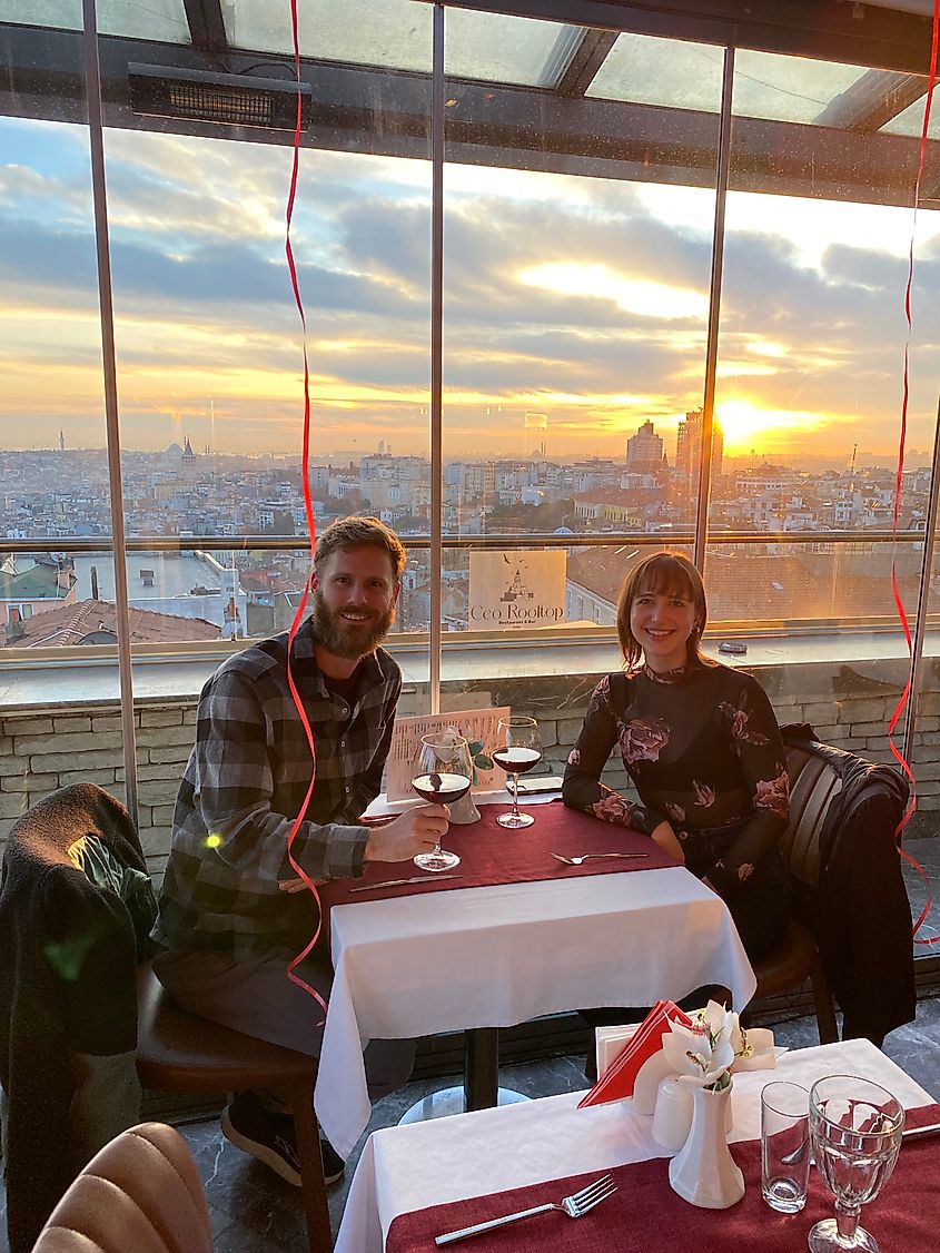 The author and his girlfriend having a romantic glass of wine at sunset atop a panoramic rooftop restaurant.