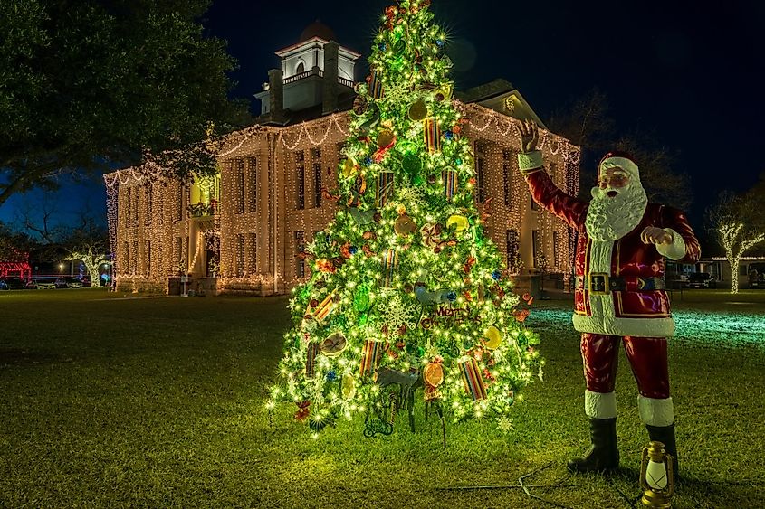 Twinkling lights on Christmas Tree with Santa statue around the courthouse each December in Johnson City, Texas.
