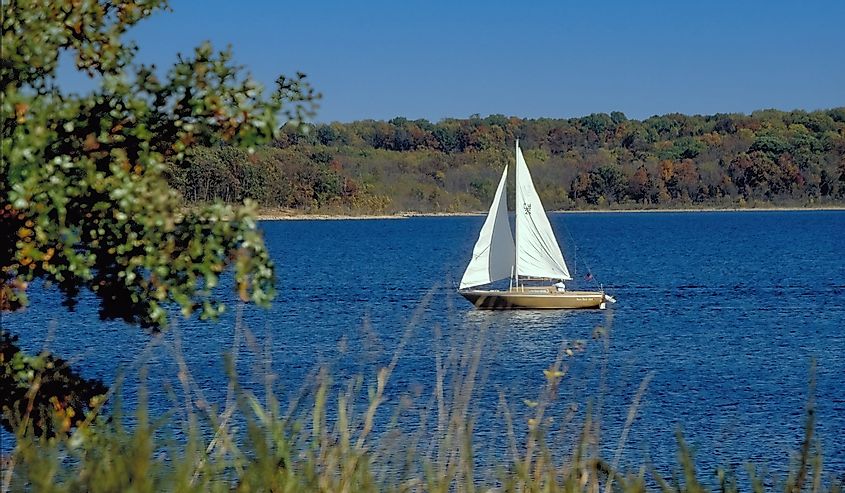 A sailboat glides over the blue waters of Stockton Lake in the Missouri Ozarks on a late summer day.