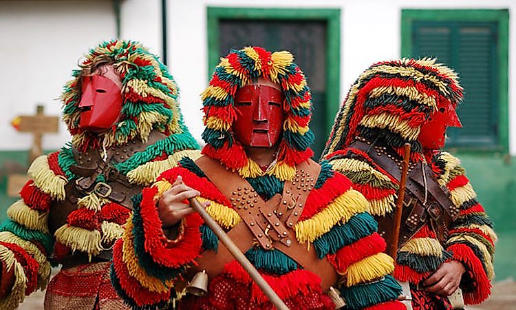 Caretos in fringed costumes and masks during Carnival in Podence, Portugal.