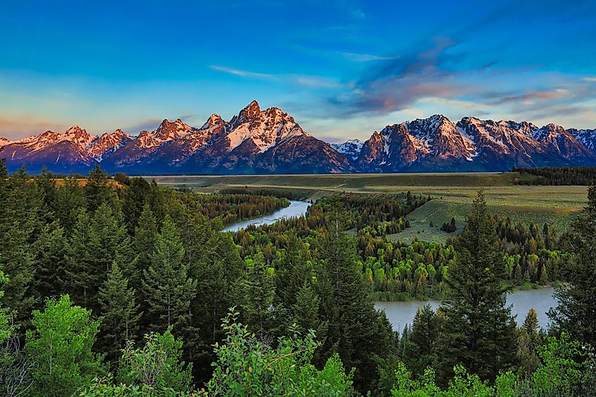 Sunrise over the Snake River Overlook in Wyoming, with the majestic Grand Tetons in the background.