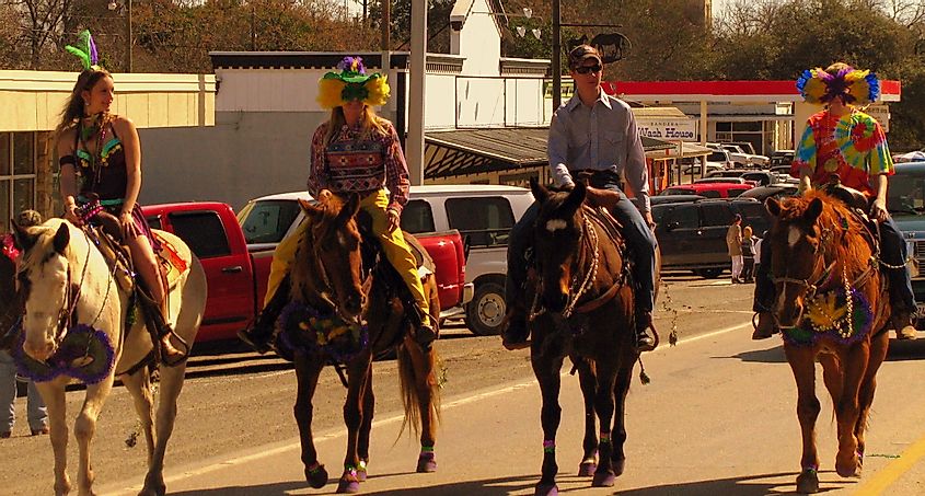 Cowboys and cowgirls celebrating Mardi Gras in Bandera, Texas.