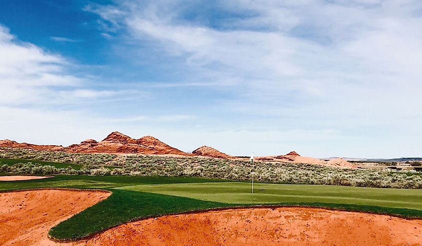 This spectacular setting of mountains, desert, and green grass is captured at the Sand Hollow Golf Resort in Southern Utah.