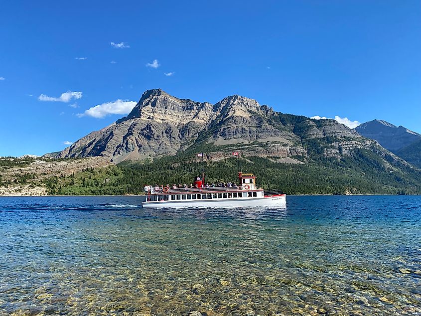 An old fashioned sternwheeler cruises along a pristine mountain lake.