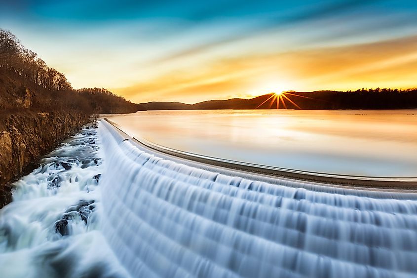 Sunrise over Croton Dam, NY, with its stepped spillway waterfall. The long exposure captures a smooth and silky effect on the falling water, creating an artistic ambiance.