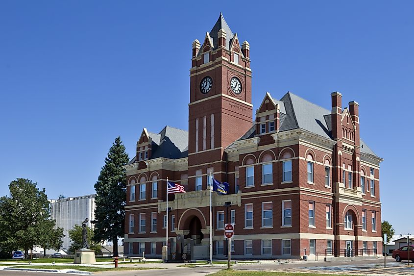 The Romanesque style Thomas County Courthouse stands near large grain elevators in Colby, Kansas.