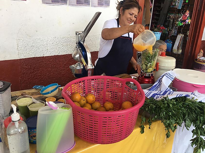 A Mexican woman squeezes fresh juice 